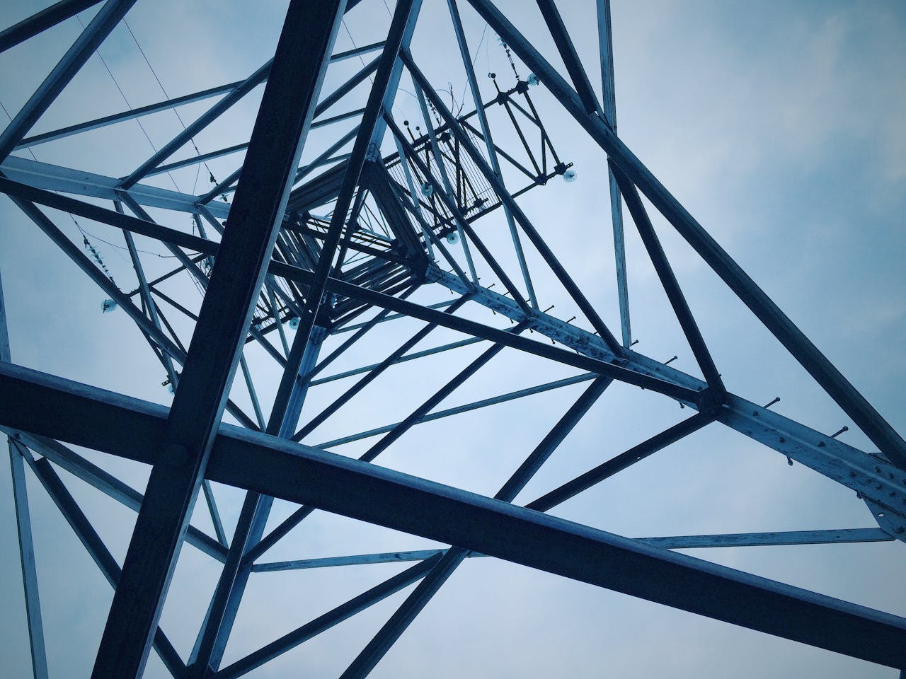 Low angle shot of a steel electricity tower against a clear sky.
